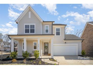 Charming two-story home with a welcoming front porch and manicured landscaping at 2105 Moss Bluff Dr, Mint Hill, NC 28227