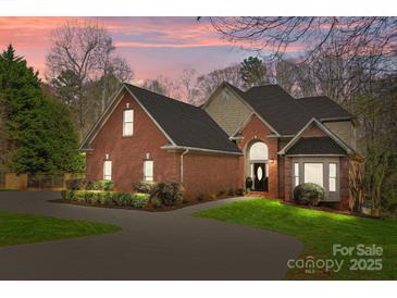 Stunning brick home with manicured landscaping and a circular driveway at sunset at 221 Colony Dr, Mooresville, NC 28115