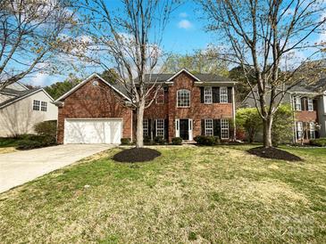 Charming two-story brick home with a well-manicured lawn and attached two car garage at 3711 Cole Mill Rd, Charlotte, NC 28270