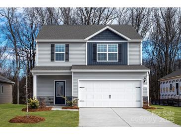 Charming two-story home with gray siding, a two-car garage and black shutters on a well-manicured lawn at 507 Maddox Dr, Shelby, NC 28152