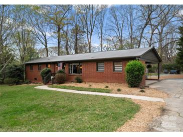 Charming brick home featuring a well-maintained lawn, inviting walkway, and a convenient carport at 801 Glendora Dr, Charlotte, NC 28212