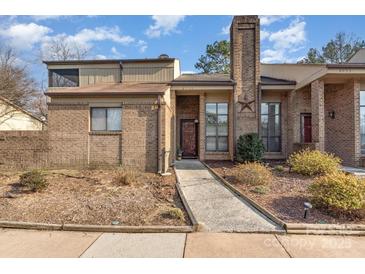 Inviting brick home showcasing a tidy front yard, walkway and a notable chimney feature at 8033 Charter Oak Ln, Charlotte, NC 28226