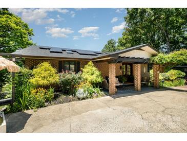 Charming brick home with a welcoming, covered front porch and beautiful landscaping at 9500 Windygap Rd, Charlotte, NC 28278