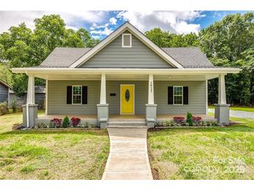 Charming single-Gathering home featuring a welcoming front porch and well-manicured landscaping at 1022 Parker St, Monroe, NC 28112