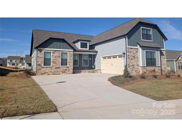 Beautiful new construction home with stone accents and a two-car garage, with a wide driveway and a manicured lawn at 1925 Hendricks St, Rock Hill, SC 29732