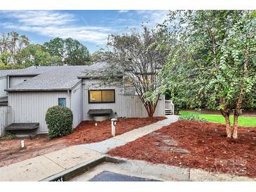 Inviting home exterior with manicured landscaping, a well-lit walkway, and mature trees at 201 Riverview Ter, Lake Wylie, SC 29710
