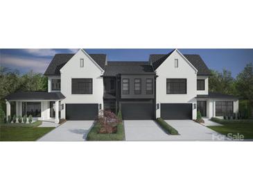 A modern townhouse with a painted white brick facade, large black framed windows, and well manicured front yard at 2924 Sharon View Rd # C, Charlotte, NC 28210
