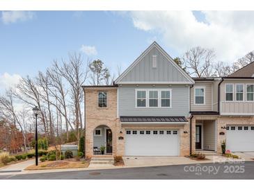 Charming townhome featuring a two-car garage, brick accents, and a welcoming front porch at 3111 Everly Enclave Way, Charlotte, NC 28210