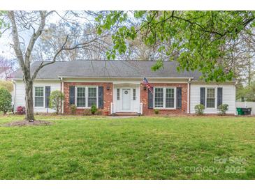 Charming single-story brick home with an American flag, black shutters, and a well-maintained lawn at 5700 Carmel Station Ave, Charlotte, NC 28226