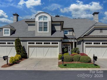 Beautiful two-story home featuring a three-car garage and well-maintained landscaping under a blue sky at 8015 Greenview Terrace Ct, Charlotte, NC 28277