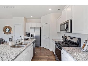 Modern kitchen with stainless steel appliances, granite counters, white cabinets and hardwood floors at 882 Two Brothers Ln, York, SC 29745