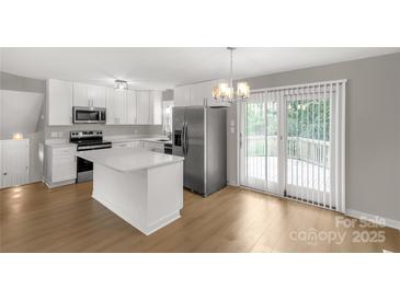 Modern kitchen features stainless steel appliances, white cabinets and island, and a sliding glass door at 2220 Ross Cauthen Rd, Lancaster, SC 29720