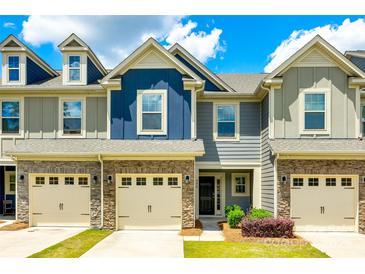 Charming townhome with stone accents, a two-car garage, and manicured lawn under a bright sky at 558 Dulaney Dr, Fort Mill, SC 29708