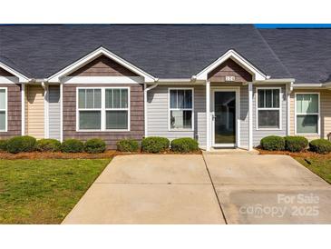 Charming home featuring manicured front yard, driveway, and inviting entryway at 104 S Canyon Rdg, Mount Holly, NC 28120