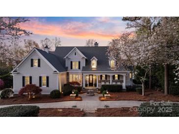 Stunning two-story home with lush landscaping, fountain, and a welcoming front porch at sunset at 111 Moors End Loop, Mooresville, NC 28117