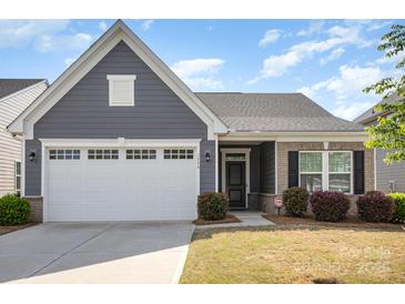 Charming one-story home with a gray exterior, brick accents, well-manicured lawn, and a two-car garage at 1774 Slippery Rock Ln, Monroe, NC 28112