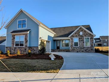Charming, stone and light blue siding, single-Gathering home featuring a manicured lawn and a curved driveway to a two-car garage at 2074 Fordhill St, Rock Hill, SC 29732