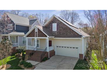 Charming home features a two-car garage, cozy front porch, and manicured lawn at 2620 Merion Hills Ct, Charlotte, NC 28269