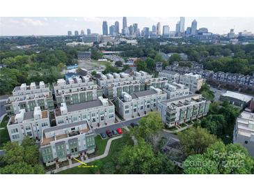 Stunning aerial view of modern townhomes with the city skyline in the background at 327 Uptown West Dr, Charlotte, NC 28208