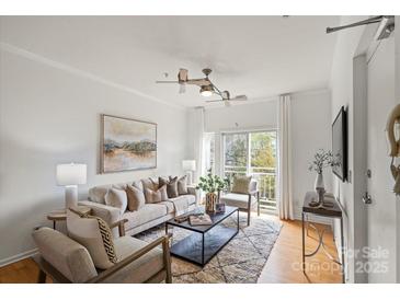 Bright living room with hardwood floors, modern ceiling fan, neutral decor, and balcony access at 3939 Picasso Ct, Charlotte, NC 28205