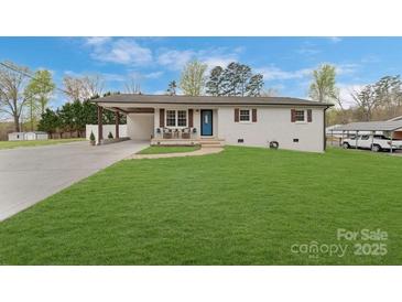 Charming home with well-maintained lawn, blue door, covered parking, and inviting front patio at 5467 Whiting Ave, Kannapolis, NC 28083
