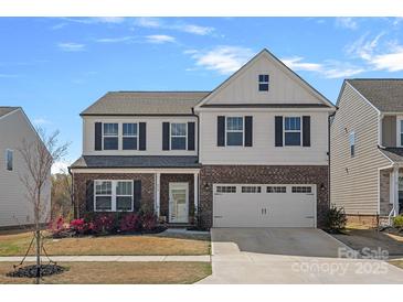 Charming two-story home features a brick and siding facade with a two-car garage and manicured landscaping at 650 Scotch Meadows Loop, Monroe, NC 28110