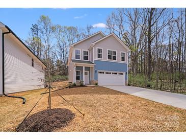 Charming two-story home featuring a two-car garage, blue and gray siding, and a well-manicured front yard at 7444 Malabar Rd # 14, Huntersville, NC 28078
