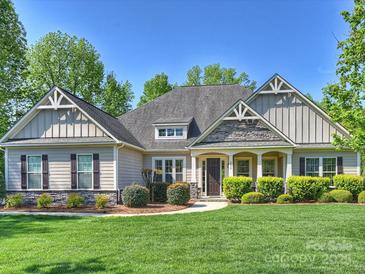 Charming single-story home featuring a manicured lawn, stone accents, and a welcoming covered front porch at 2030 Gloucester St, Weddington, NC 28104
