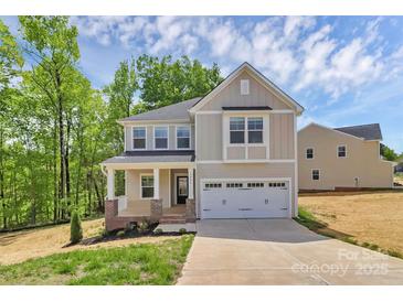 Charming two-story home featuring a covered porch, attached two-car garage, and professionally landscaped yard at 3204 Leah Elizabeth Ln, Monroe, NC 28110