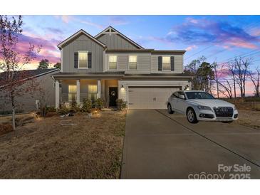 Charming two-story home featuring a well-maintained lawn, a two-car garage, and neutral-colored siding at 4104 Armstrong Farm Dr, Belmont, NC 28012