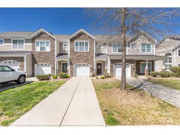 Beautiful townhome exterior featuring a stone facade, attached garages, and well-maintained landscaping on a sunny day at 4644 Craigmoss Ln, Charlotte, NC 28278