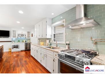Modern kitchen features stainless steel appliances, light cabinetry, and lovely tile backsplash at 552 Odell School Rd, Concord, NC 28027