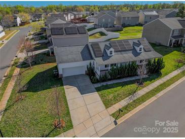 Charming two-story home featuring solar panels, a front porch, an attached garage, and a concrete driveway at 6308 Brumit Ln, Charlotte, NC 28269