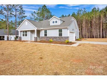 Charming single-Gathering home featuring stone accents, a two-car garage, and manicured landscaping at 700 Sunset Pointe Dr, Salisbury, NC 28146