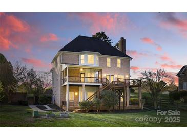 A beautiful brick home showcasing a large backyard, dual decks, and outdoor living spaces, perfect for entertaining at 13833 Jonathans Ridge Rd, Mint Hill, NC 28227
