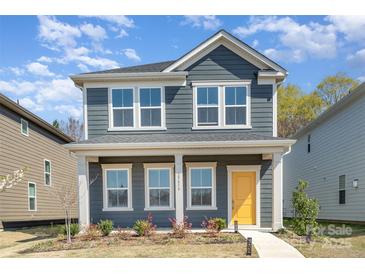 Charming two-story home with a welcoming yellow front door and beautiful landscaping at 15616 Parkside Crossing Dr, Charlotte, NC 28278