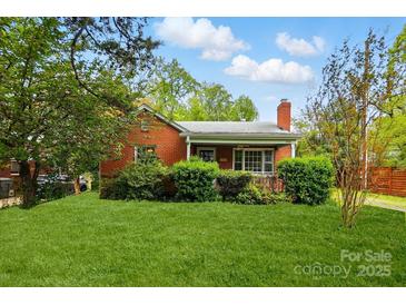 Charming red brick home featuring a well-manicured lawn and mature landscaping at 3221 Cosby Pl, Charlotte, NC 28205