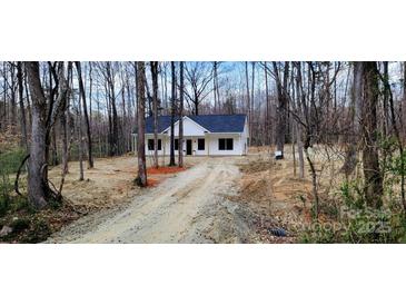 A charming exterior view of a modern home nestled among the trees with a gravel driveway at 330 Fiber Acres A St, Cleveland, NC 27013