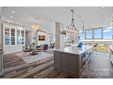Bright open floor plan boasts hardwood floors, dining area, and a spacious kitchen with an oversized kitchen island at 333 W Trade St # 2704, Charlotte, NC 28202