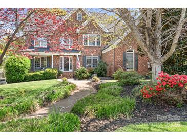 Charming brick home with a beautifully landscaped front yard and a welcoming front porch at 3934 Blue Dory Ln, Denver, NC 28037