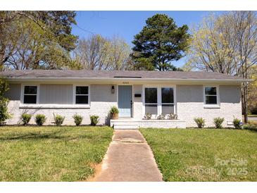 Charming painted brick home with a well-manicured lawn and inviting light blue front door at 4343 Dowling Dr, Charlotte, NC 28205