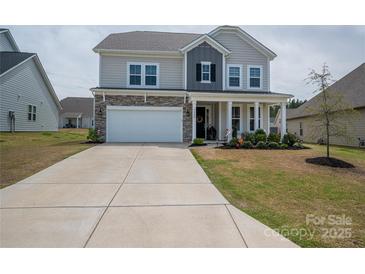 Charming two-story home with stone accents, covered porch, well-kept lawn, and a spacious driveway at 7924 Creek Park Dr, Denver, NC 28037