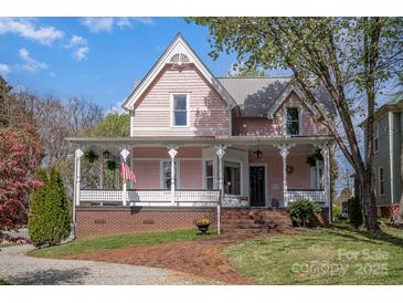 Charming pink two-story home with a welcoming front porch and well-manicured lawn at 820 N Main St, Salisbury, NC 28144
