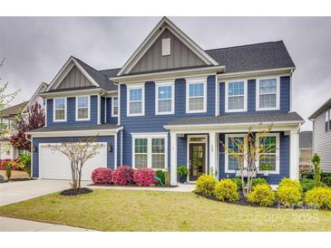 Stunning two-story home with a blue exterior, manicured lawn and colorful landscaping at 822 Flatwater Ct, Fort Mill, SC 29708
