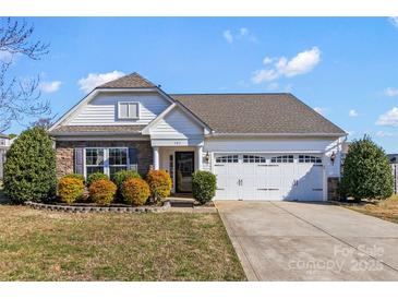 Charming single-story home featuring a manicured lawn, stone accents, and an attached two-car garage at 103 Karlyn Ct, Mooresville, NC 28115