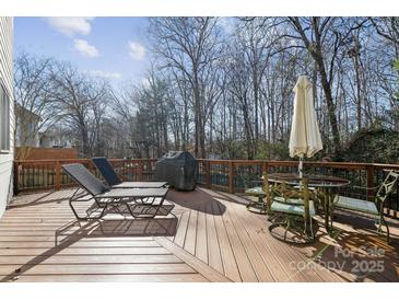 Spacious wooden deck features lounge chairs, an outdoor dining set, and wooded views at 1102 High Brook Dr, Waxhaw, NC 28173