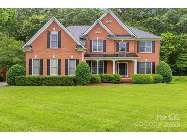 Charming brick two-story home with a well-manicured lawn and neatly trimmed hedges at 1102 High Brook Dr, Waxhaw, NC 28173