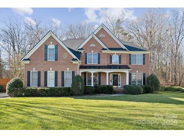Charming two-story brick home with a lush, well-manicured lawn and manicured shrubbery at 1102 High Brook Dr, Waxhaw, NC 28173