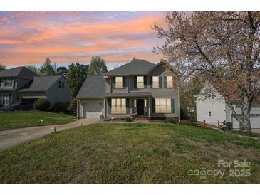 Charming two-story home with attached garage, lawn, and professional landscaping at 11615 Hidden Grove Trl, Charlotte, NC 28215