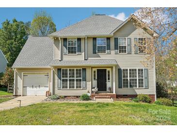 Charming two-story home featuring a well-manicured lawn and attached garage at 11615 Hidden Grove Trl, Charlotte, NC 28215